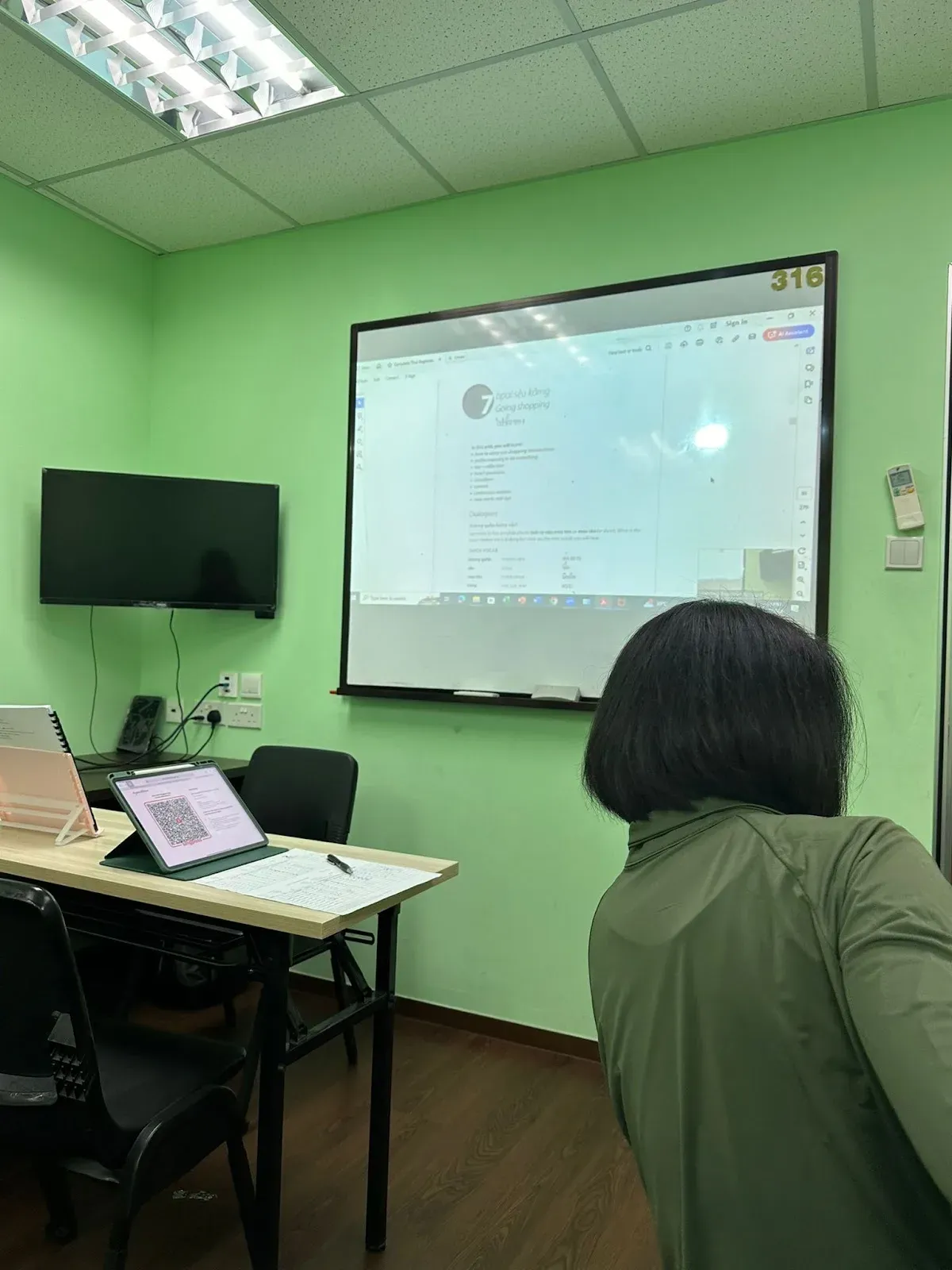 A lesson on the classroom screen, with a student following along