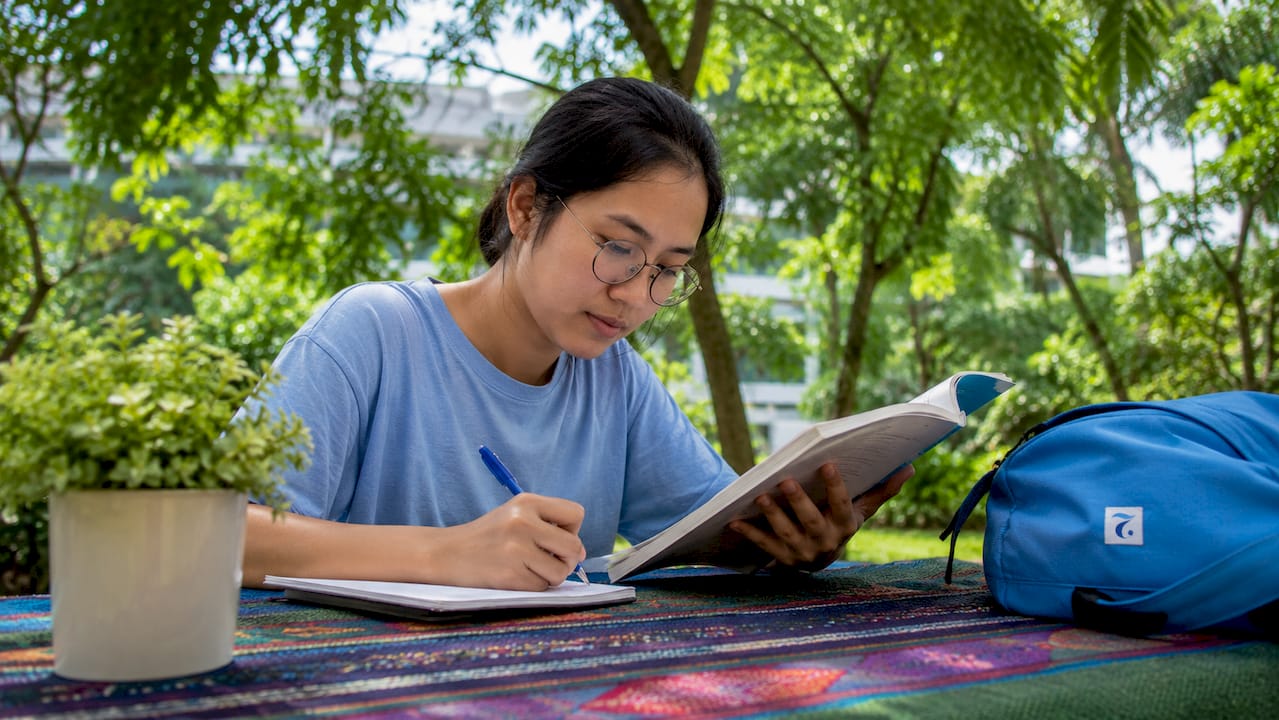 Woman studying formal and informal Thai outdoors