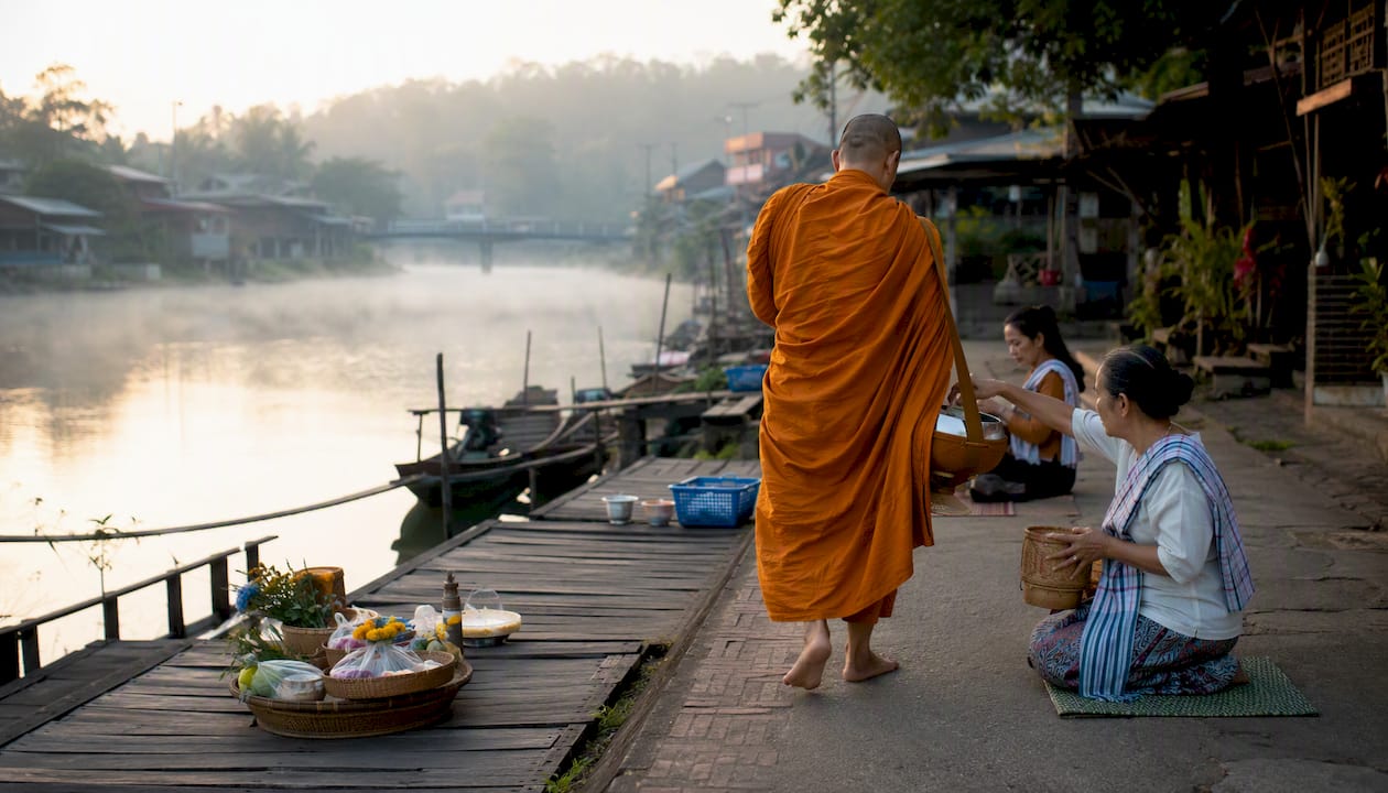 Monk receiving alms in Thai village morning