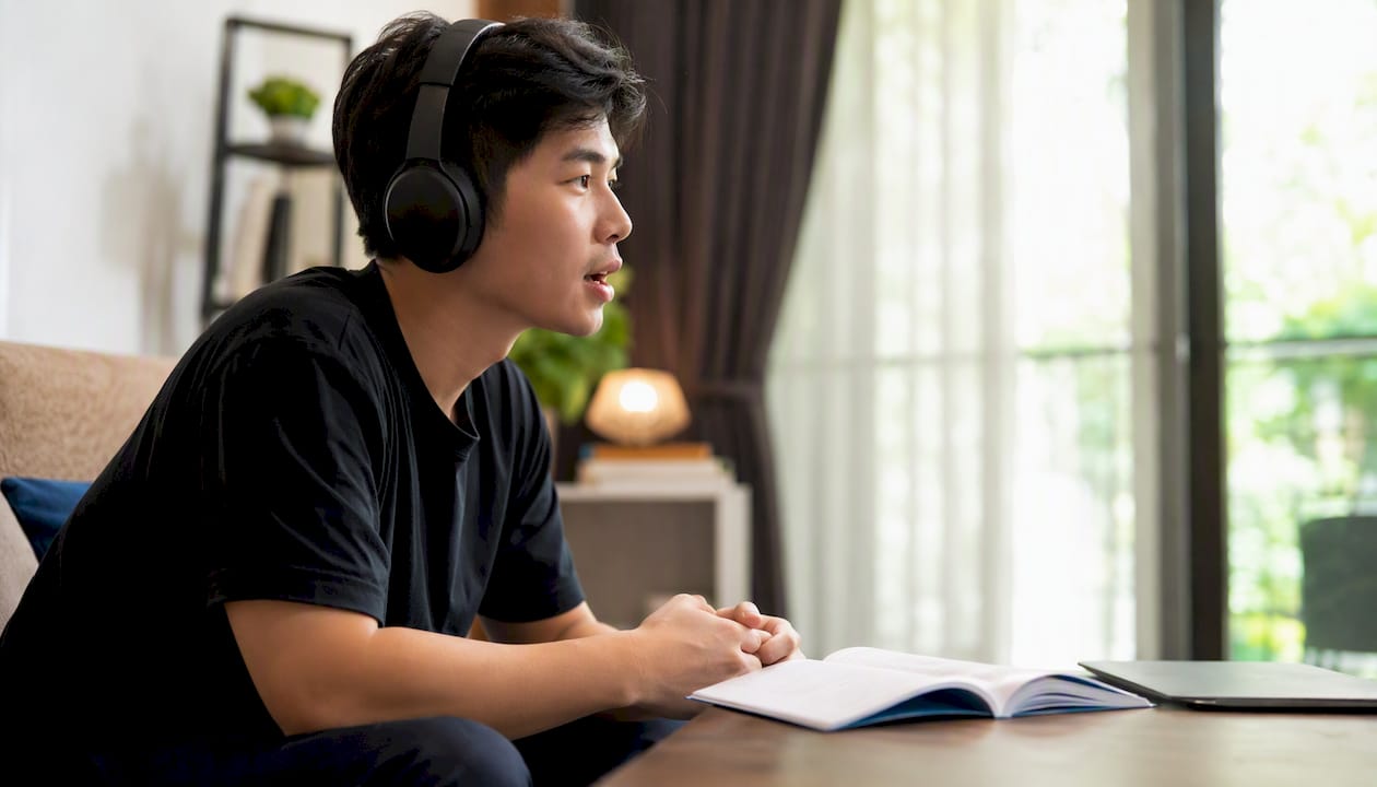 Learner practicing Thai tones with headphones