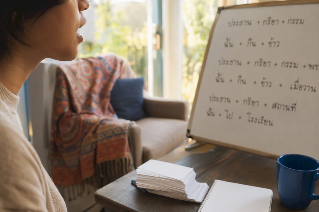 Learner practicing Thai sentences in study room
