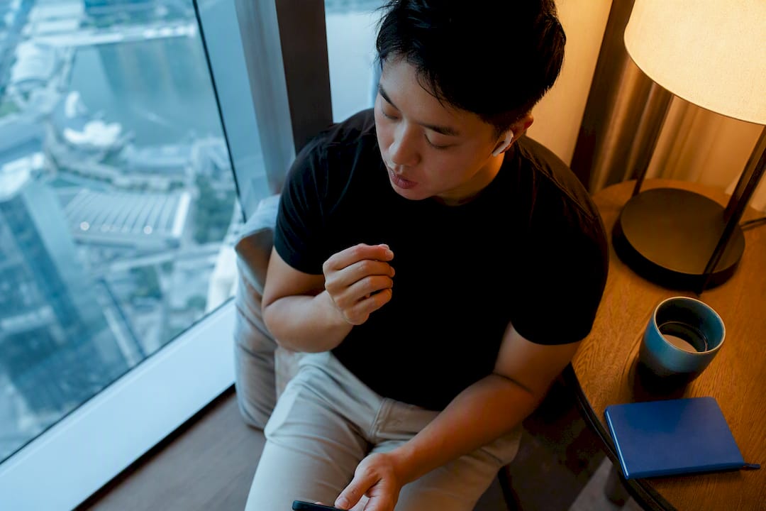 Beginner practicing Thai listening beside window